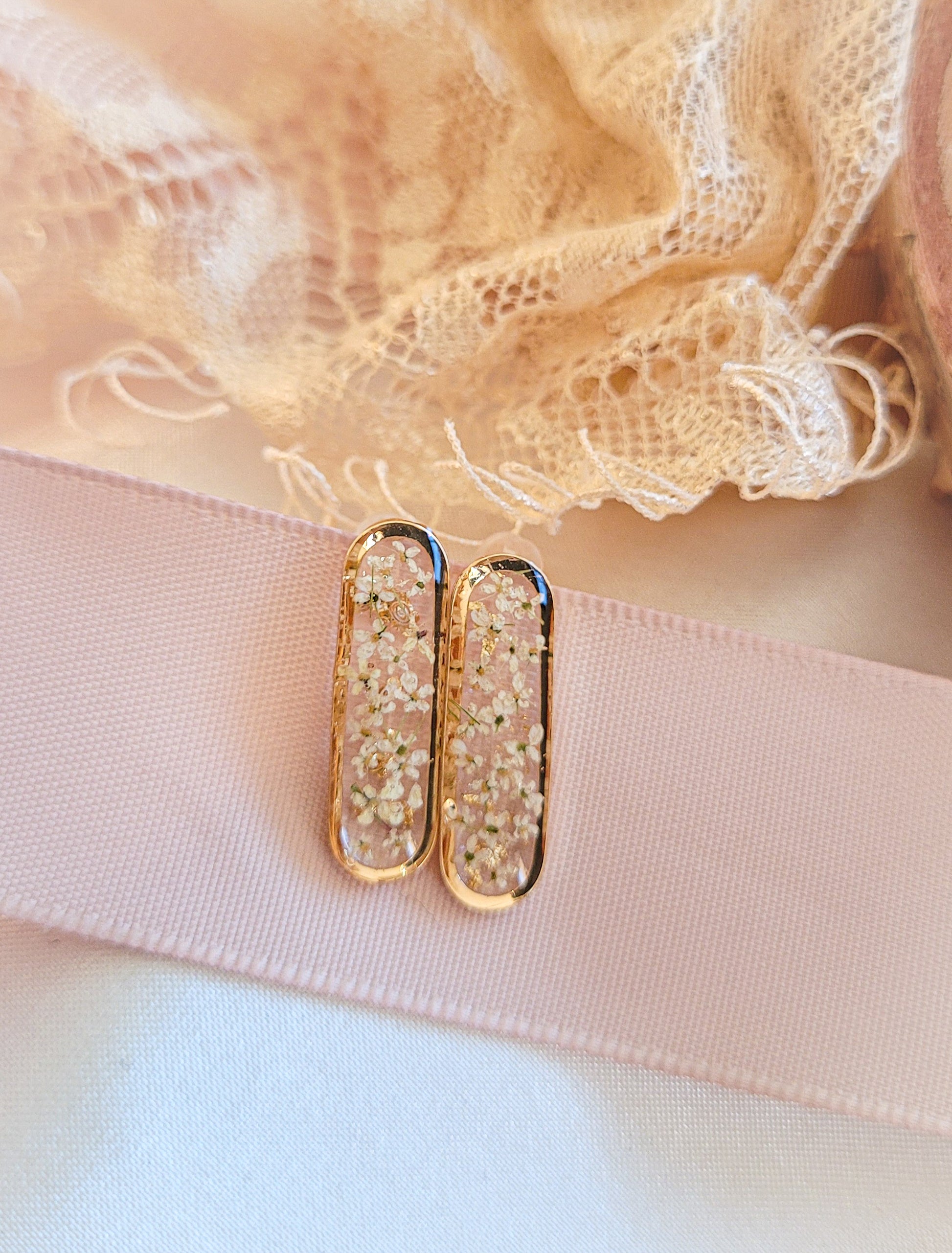 Boucle d'oreille avec des fleurs blanches