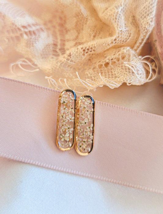 Boucle d'oreille avec des fleurs blanches